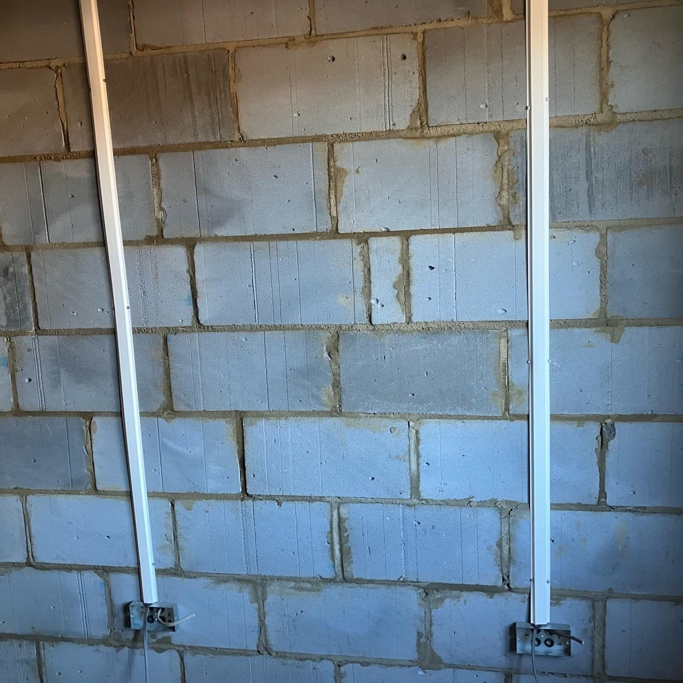 Cable capping run down a blockwork garage wall to the back boxes during first fix