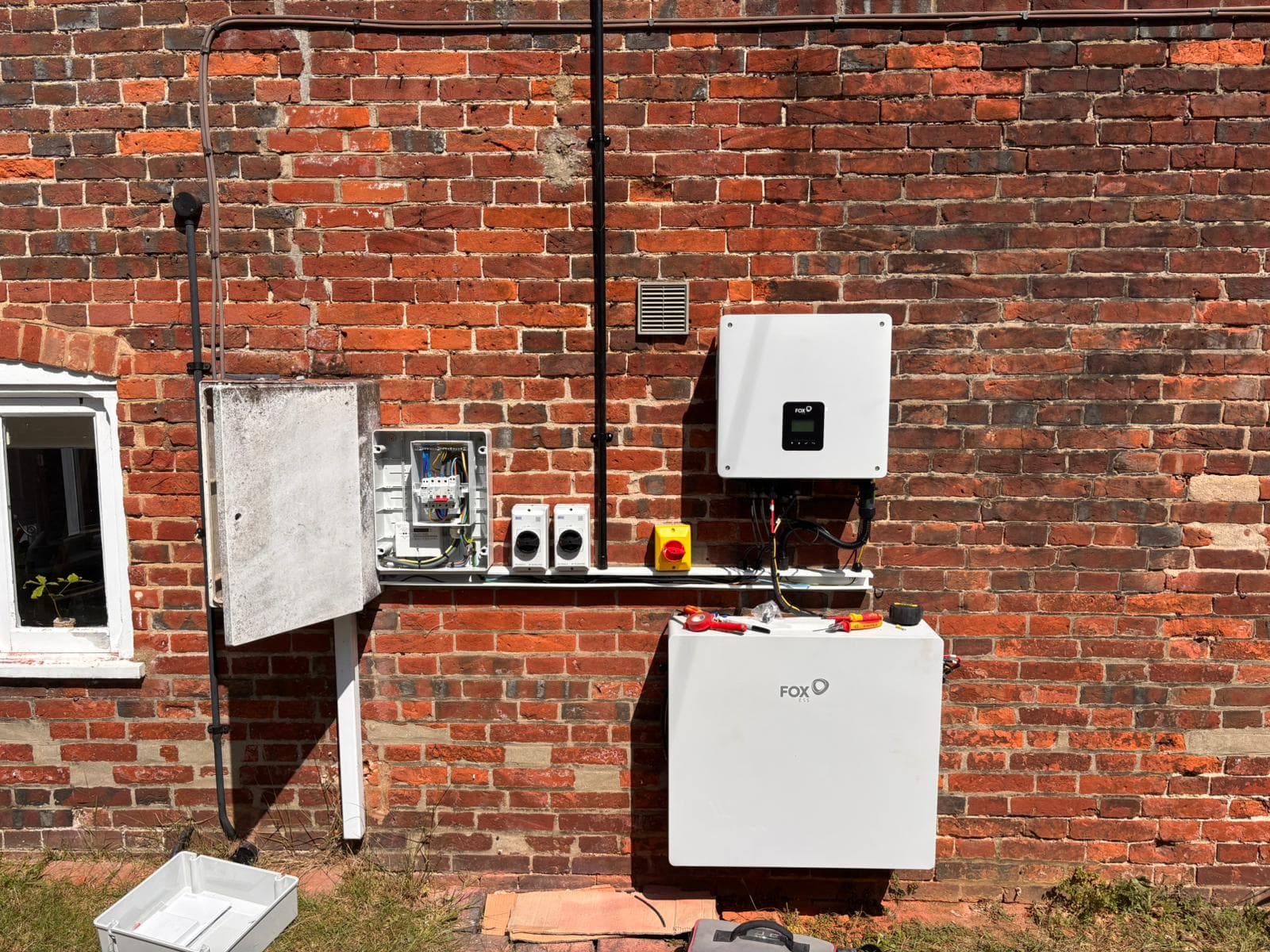 Fox ESS solar inverter and battery storage fitted to an external brick wall with isolators and a new board